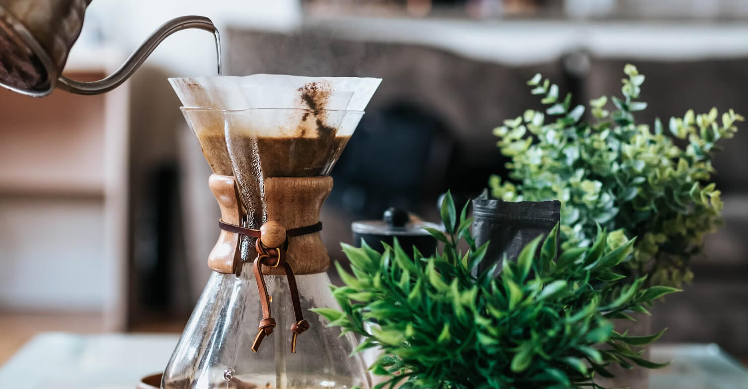 Coffee being poured slowly into a cup in morning light
